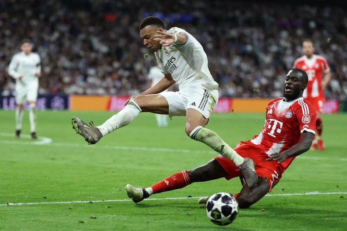 Real Madrid's French forward, Kylian Mbappe (left) vying for the ball with Bayern Munich's French defender, Dayot Upamecano during the UEFA Champions League quarter final first leg football match between Real Madrid CF and FC Bayern Munich, at Santiago Bernabeu Stadium in Madrid, on April 7, 2026. 