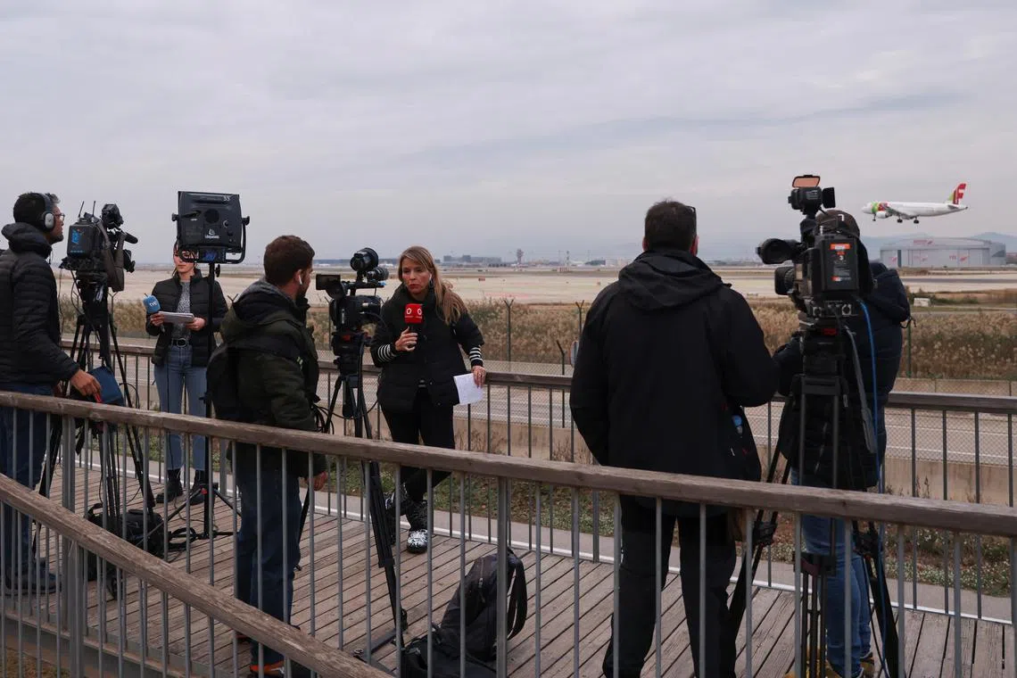 Journalists gather after a commercial airplane flying from Morocco to Turkey made an emergency landing in Barcelona's El Prat airport in the early hours and 28 would-be migrants on board ran away across the tarmac in Barcelona, Spain December 7, 2022. REUTERS/Nacho Doce REFILE - QUALITY REPEAT