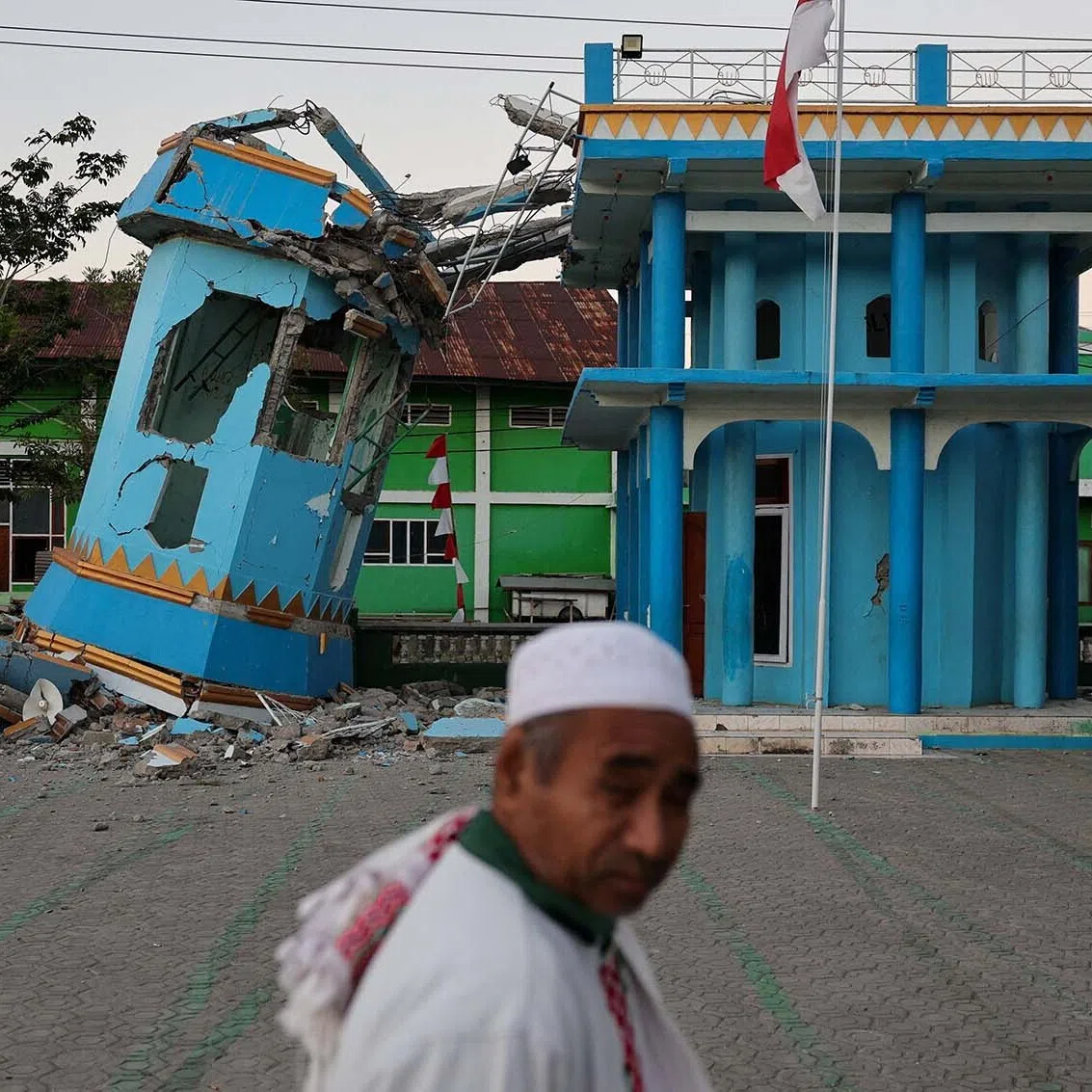 A person walks past the heavily damaged Nurul Huda mosque following an earthquake in Reok, East Nusa Tenggara province, Indonesia, August 18, 2026. REUTERS/Willy Kurniawan TPX IMAGES OF THE DAY