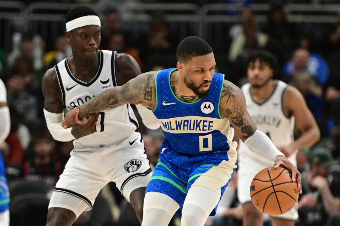 Milwaukee Bucks guard Damian Lillard is guarded by Brooklyn Nets guard Dennis Schroder in the third quarter at Fiserv Forum.