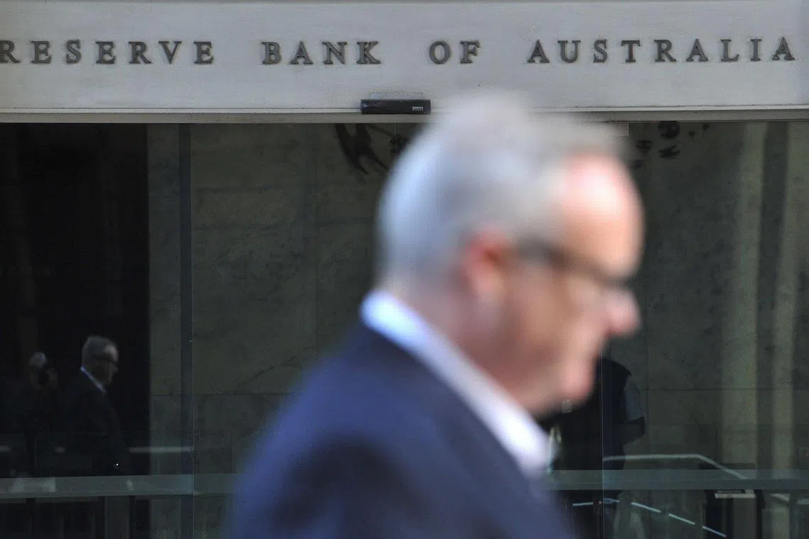 A man walks past the Reserve Bank of Australia building in the central business district of Sydney on June 7, 2022. - Australia's central bank raised interest rates by a higher-than-expected half percentage point on June 7 and warned of more increases, trying to rein in "significantly" increased inflation. (Photo by Muhammad FAROOQ / AFP)