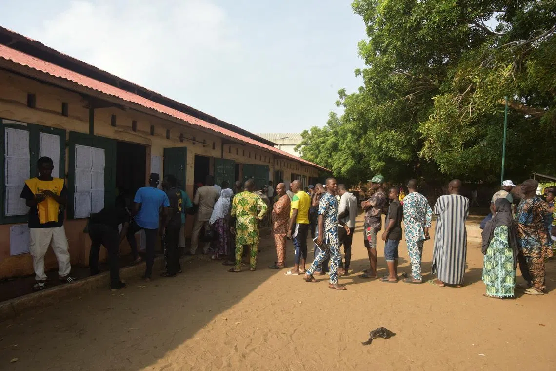 People wait in line to cast their vote at a polling station during the parliamentary election, in Cotonou, Benin, January 11, 2026. REUTERS/Charles Placide Tossou