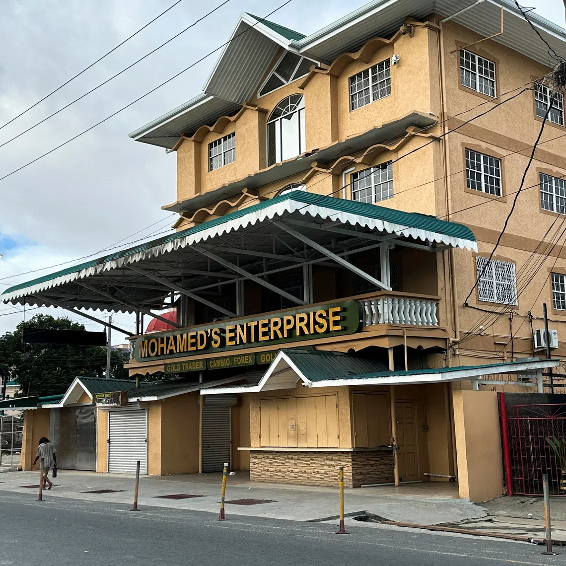 FILE PHOTO: A man passes by Mohamed's Enterprise office in Georgetown, Guyana, June 29, 2023. REUTERS/Sabrina Valle/File Photo