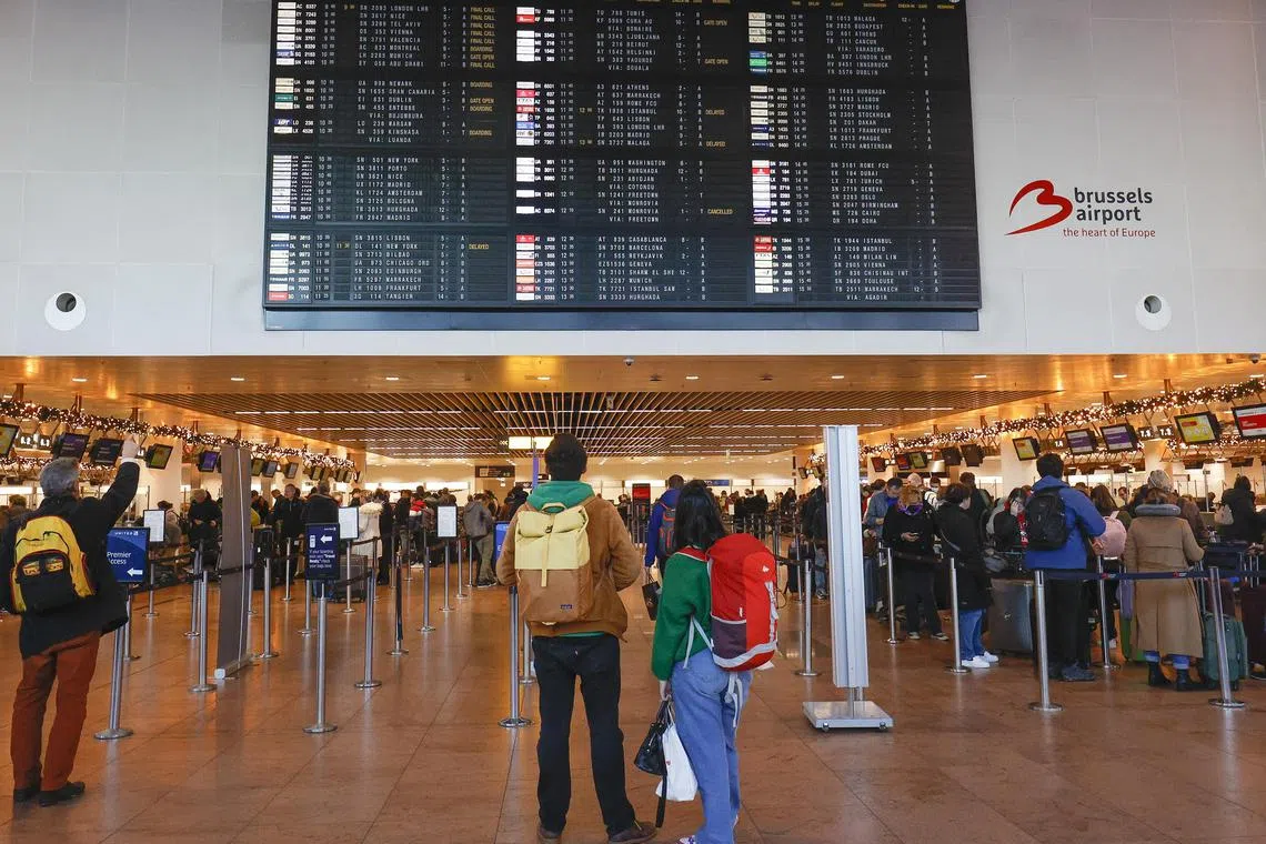 Travellers check flights at the main hall of Brussels Airport in Zaventem, Belgium, on Jan 8, 2023. 