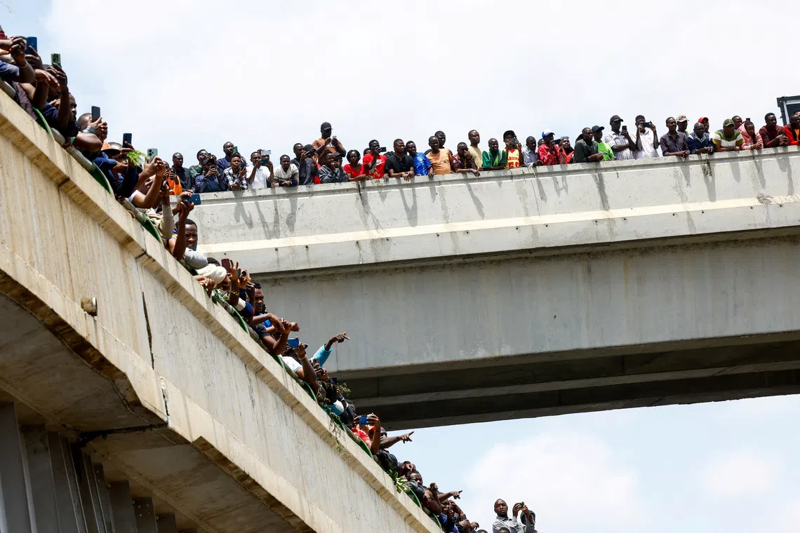 People gathering at the Mombasa road to watch the convoy carrying the body of former Kenyan Prime Minister Raila Odinga, in Nairobi, Kenya, Oct 16, 2025.