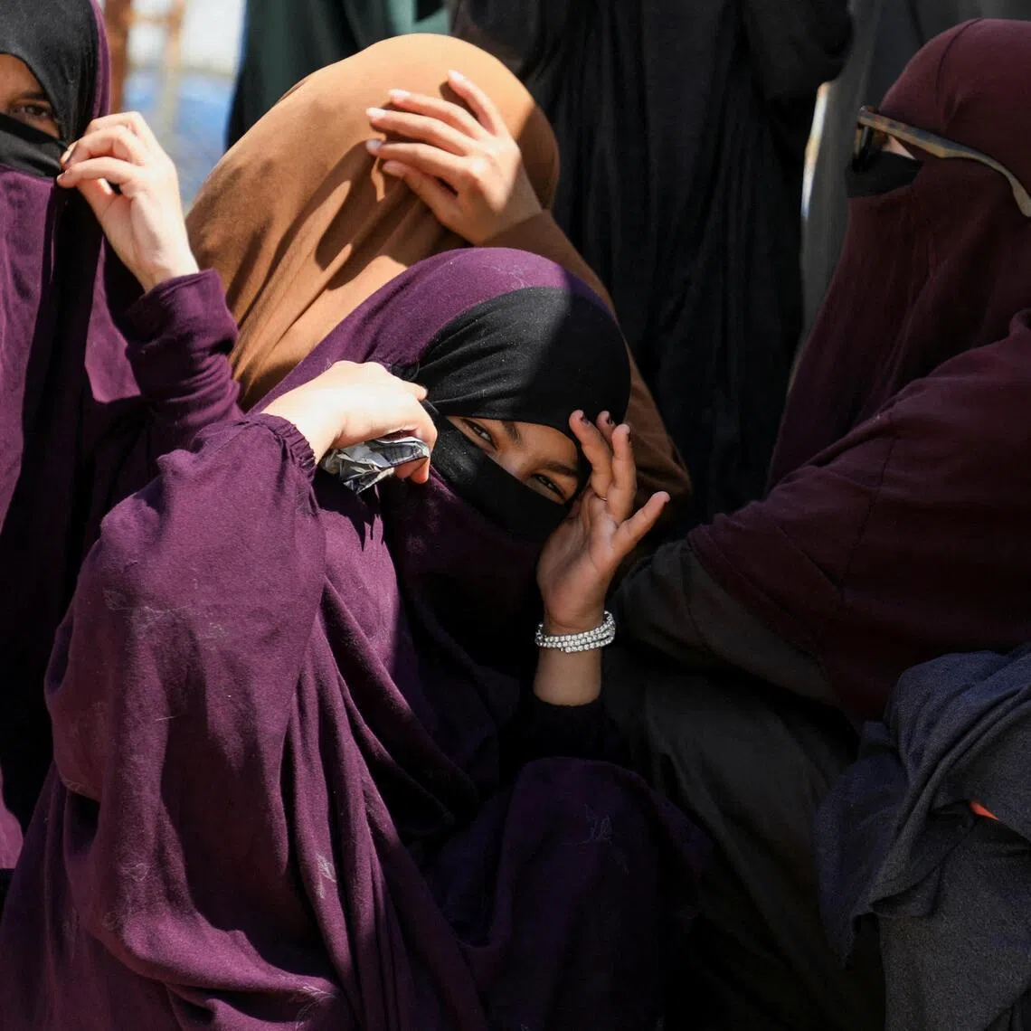 Members of Australian families believed to be linked to the Islamic State militants wait to leave Roj camp near Derik, Syria.