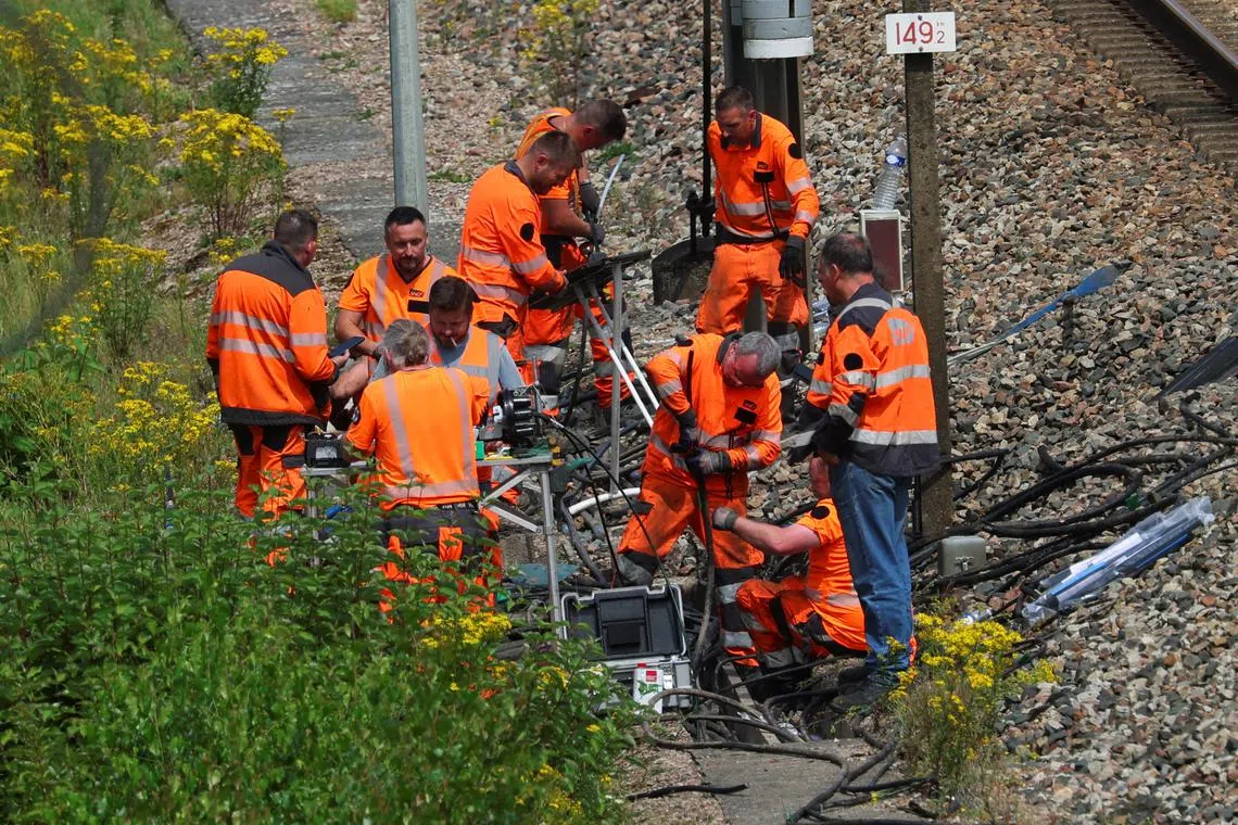 SNCF railway workers work at the site where vandals targeted France's high-speed train network with a series of coordinated actions that brought major disruption, ahead of the Paris 2024 Olympics opening ceremony, in Croisilles, northern France  July 26, 2024. REUTERS/Brian Snyder
