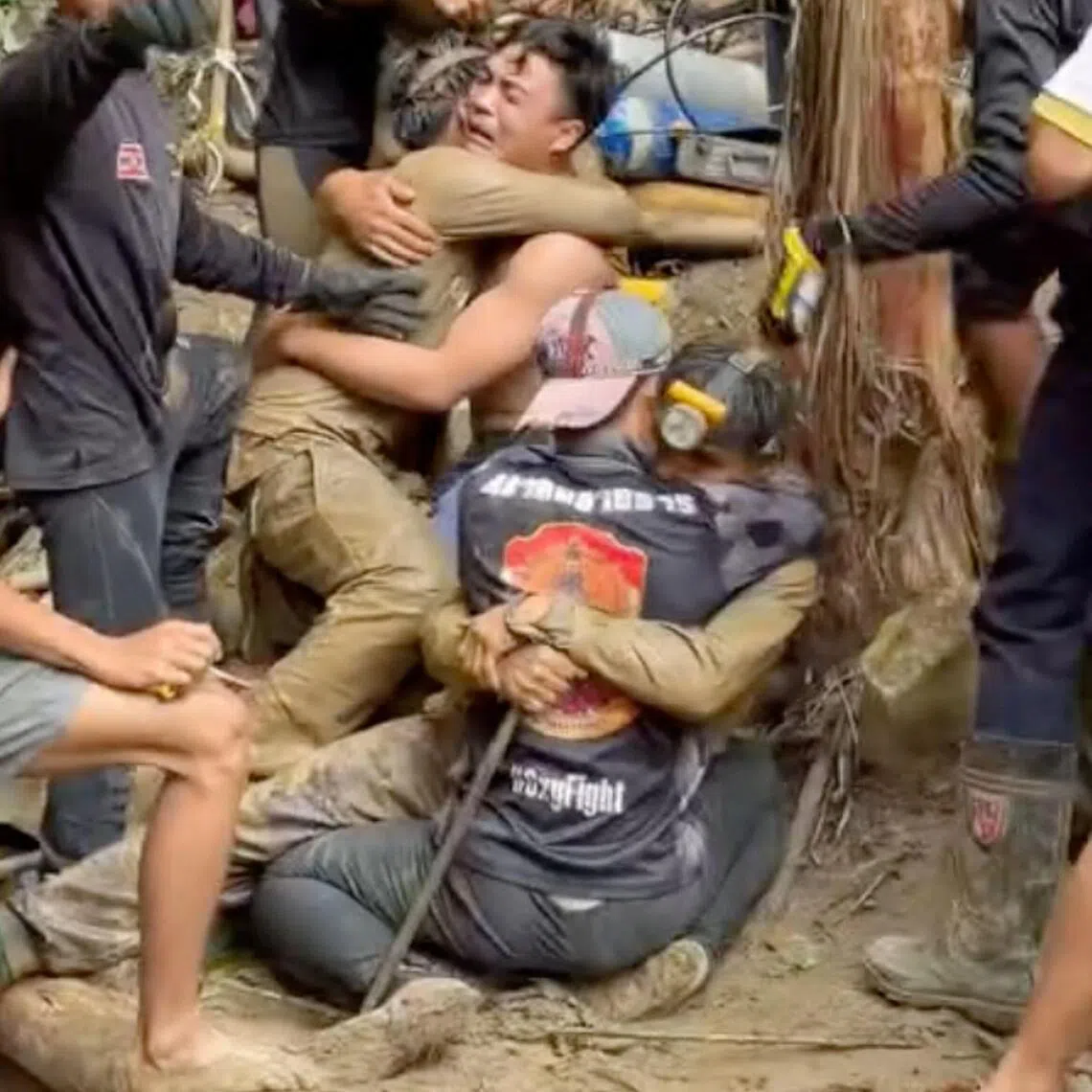 Two men being hugged after they were rescued from a semi-submerged cave in Laos' central Xaysomboun province on May 30.