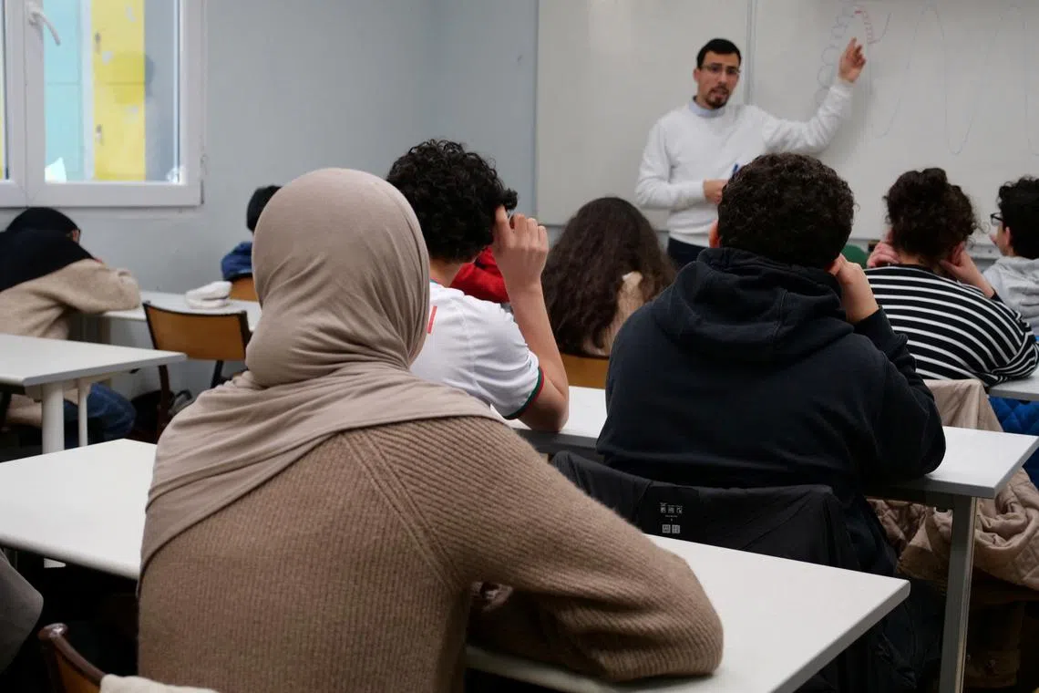 FILE PHOTO: Middle school students, some wearing a hijab, listen to teacher Ilyas Laarej during an Islamic ethics class at the Averroes school, France's biggest Muslim educational institution that has lost its state funding on grounds of administrative failures and questionable teaching practises, in Lille, France, March 19, 2024. REUTERS/Ardee Napolitano/File Photo