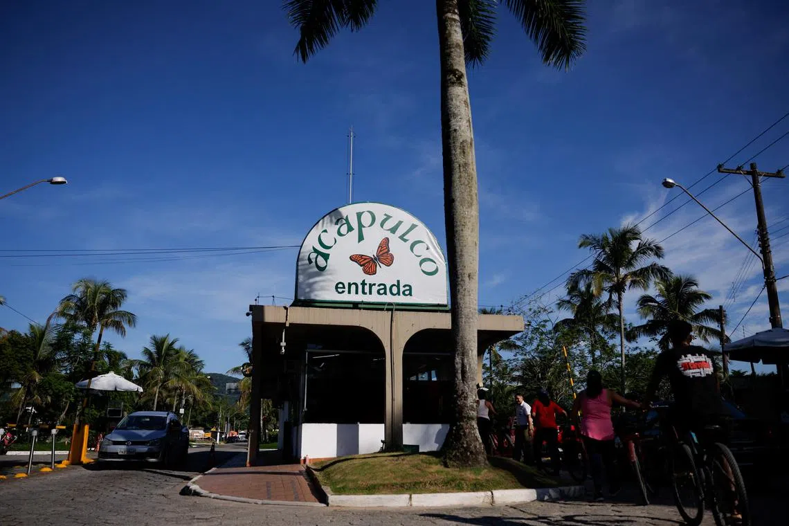 People pass near the entrance of the residential condominium named Acapulco where Brazilian soccer player Robinho has one of his houses, after the Special Court of the Brazilian Superior Court of Justice upheld the Italian court's sentence for rape against Robinho, in Guaruja, Brazil, March 21, 2024. REUTERS/Amanda Perobelli