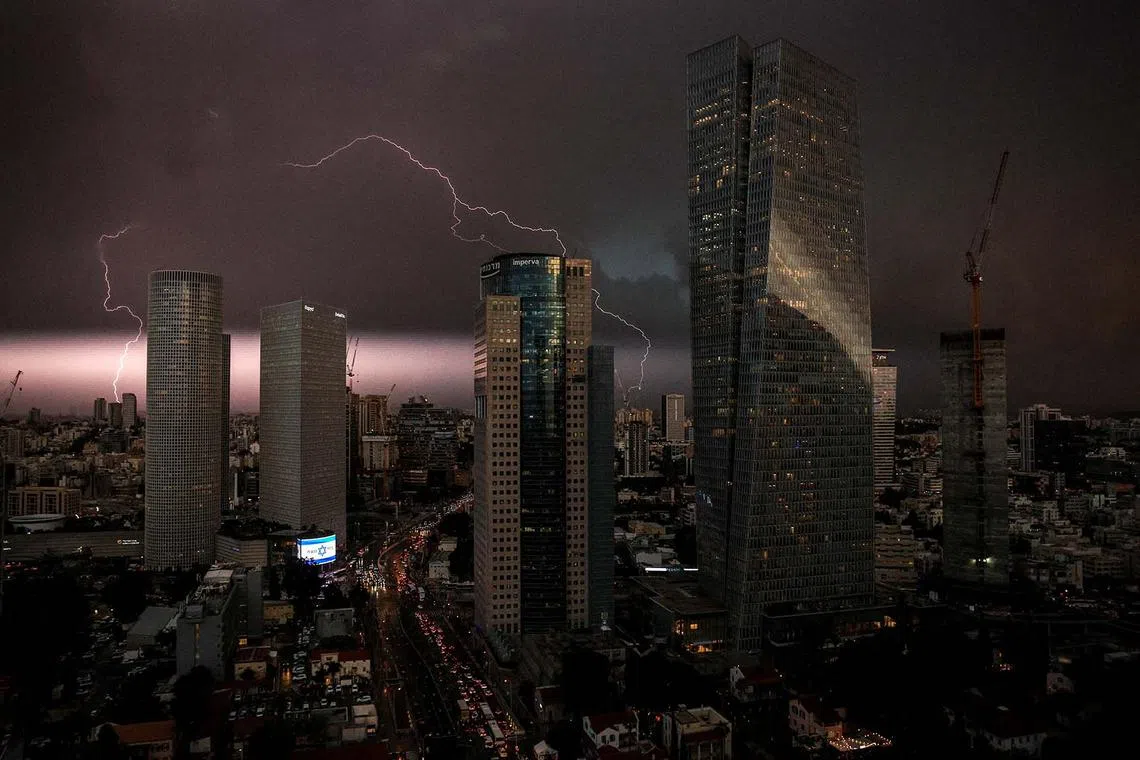 An Israeli flag is seen as lightning strikes over the sky in Tel Aviv, Israel, amid the ongoing conflict between Israel and the Palestinian Islamist group Hamas, in Gaza Strip, December 12, 2023. REUTERS/Violeta Santos Moura TPX IMAGES OF THE DAY
