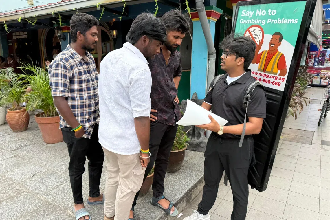 An NCPG poster walker sharing information on gambling risks with migrant workers.
