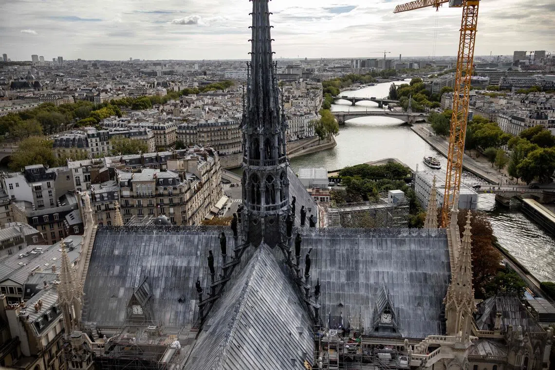 This photograph shows a view of the Notre-Dame de Paris Cathedral's spire and roof with the river Seine in the background, taken from the top of the cathedral's south tower, three days ahead of the Tours de Notre-Dame circuit reopening to the public following the 2019 fire that ravaged the cathedral, in Paris on September 17, 2025. (Photo by Guillaume BAPTISTE / AFP)