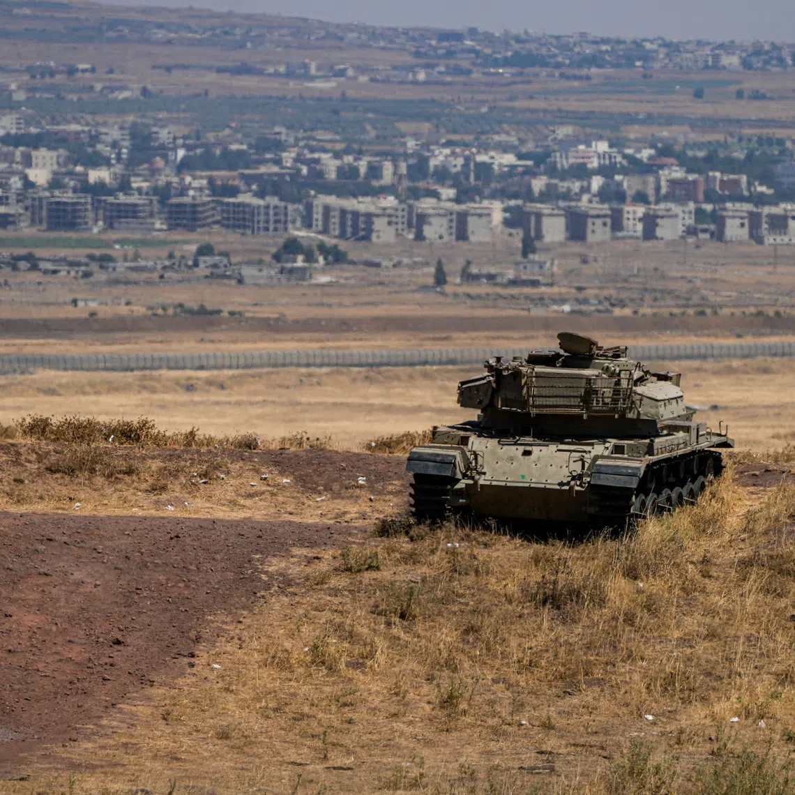 FILE PHOTO: An Israeli tank stands in position near the ceasefire line between the Israeli-occupied Golan Heights and Syria, on its Israeli side August 20, 2026. REUTERS/Ayal Margolin/File Photo