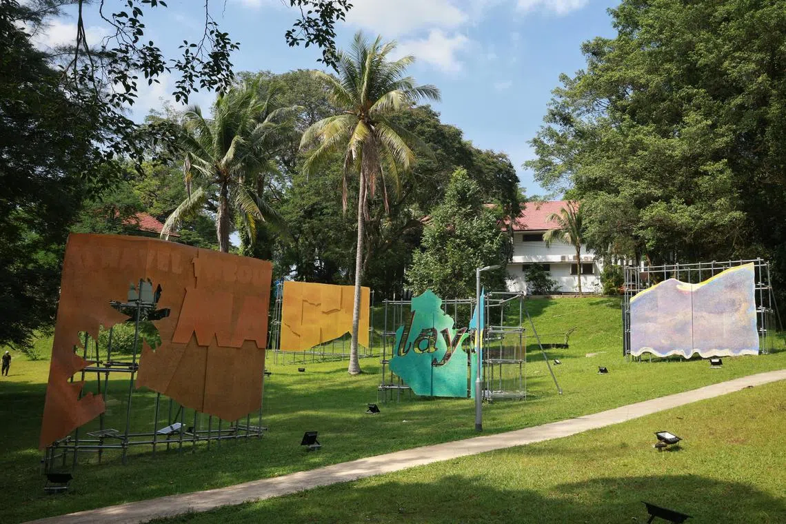 Artist Hilmi Johandi’s Stagecraft: Landscaped Grounds, a series of billboard-sized prints constructed from fragments and collages of early 20th century travel advertisements of the Federated Malay States Railways (1901–1948), staged along an open path at Wessex Estate on Aug 10, 2023. Feature on art in outdoor public spaces.