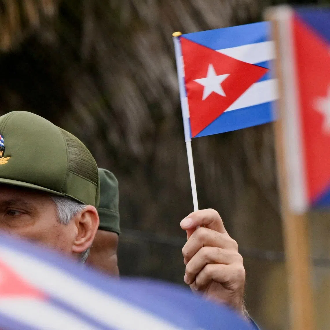 FILE PHOTO: Cuba's President Miguel Diaz-Canel waves a Cuban flag during a march outside the U.S. Embassy to protest against what they denounce as U.S. aggression in the region, in Havana, Cuba, January 16, 2026. REUTERS/Norlys Perez/File Photo