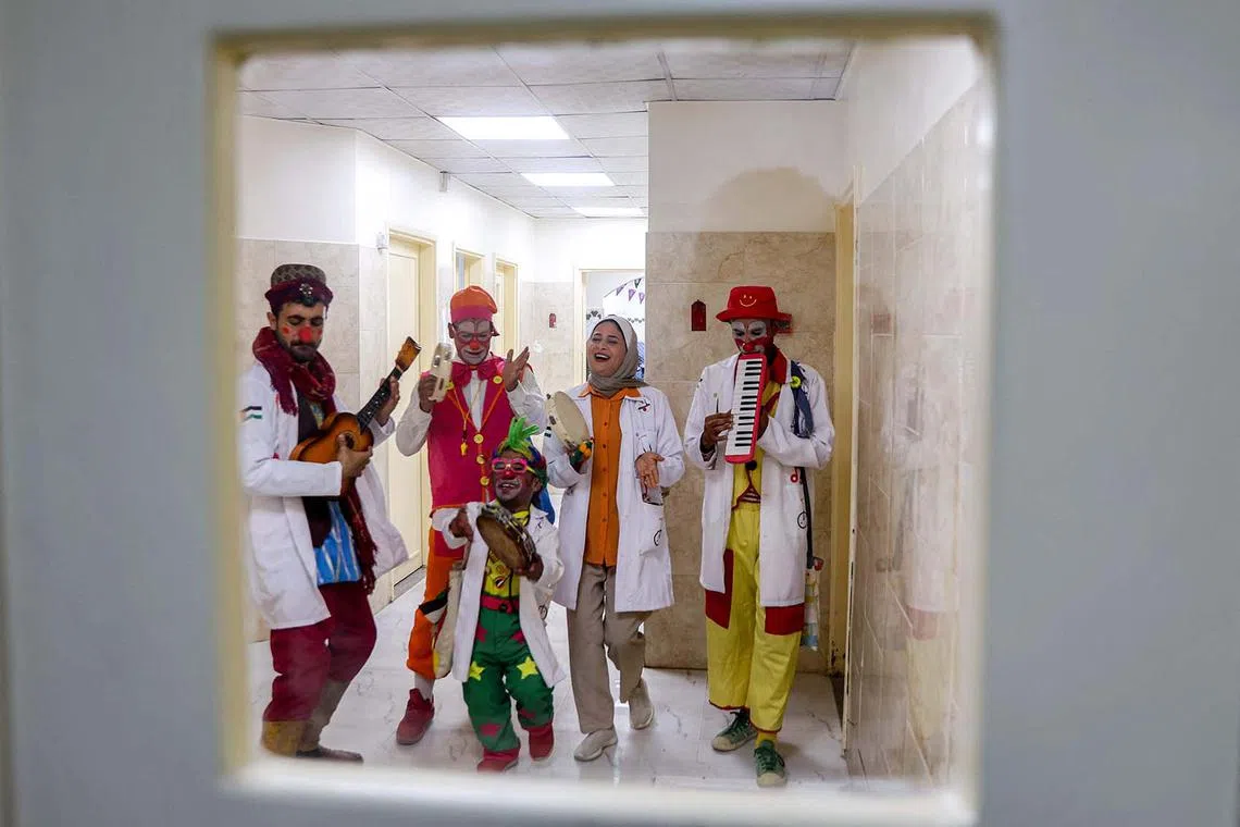 TOPSHOT - Members of the Gaza Circus School relief team perform in a hallway at the Abdelaziz al-Rantisi Hospital in Gaza City on April 15, 2025. Israel said on April 12 that it planned to expand its military offensive in Gaza after seizing a new corridor as part of a broader effort to take large parts of the war-battered Palestinian territory. The previous truce with the Palestinian Hamas movement brokered by the US, Egypt, and Qatar which took effect on January 19 collapsed on March 18 as Israel resumed intense strikes on Gaza. (Photo by Omar AL-QATTAA / AFP)