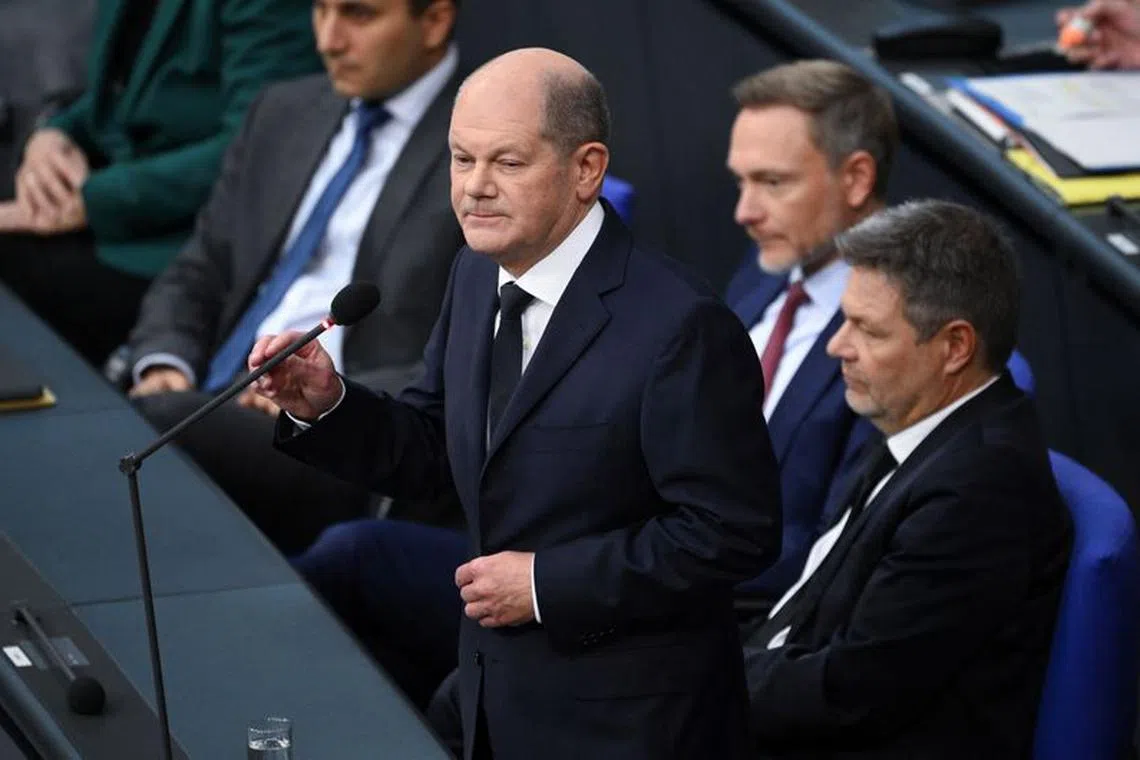 FILE PHOTO: Chancellor Olaf Scholz is watched by Finance Minister Christian Lindner and Economy and Climate Minister Robert Habeck during a hearing at Germany’s lower house of parliament Bundestag following the ruling of Germany's Constitutional court that the government's re-location of 60 billion euros ($65 billion USD) of unused debt from the pandemic era to climate fund was illegal, in Berlin, Germany, November 15, 2023.   REUTERS/Annegret Hilse/File photo