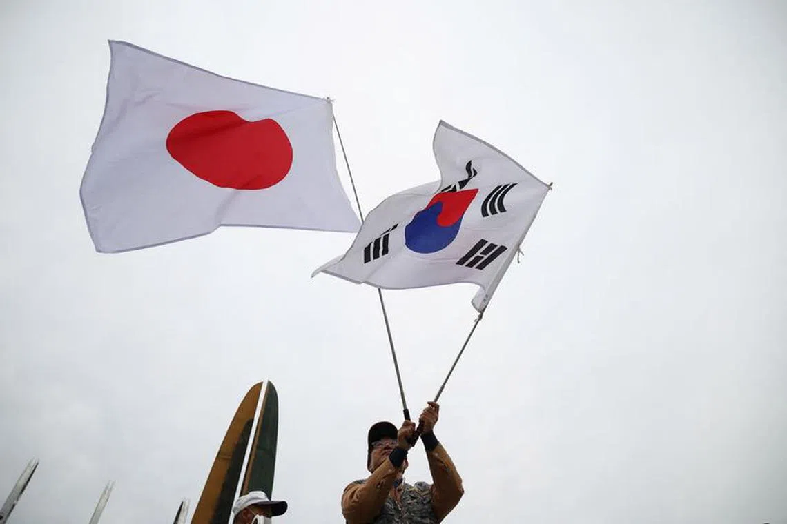 A member of a conservative civic group waves national flags of Japan and South Korea during a pro-Japan rally near the Presidential Office in Seoul, South Korea, May 7, 2023.  REUTERS/Kim Hong-Ji/ File Photo
