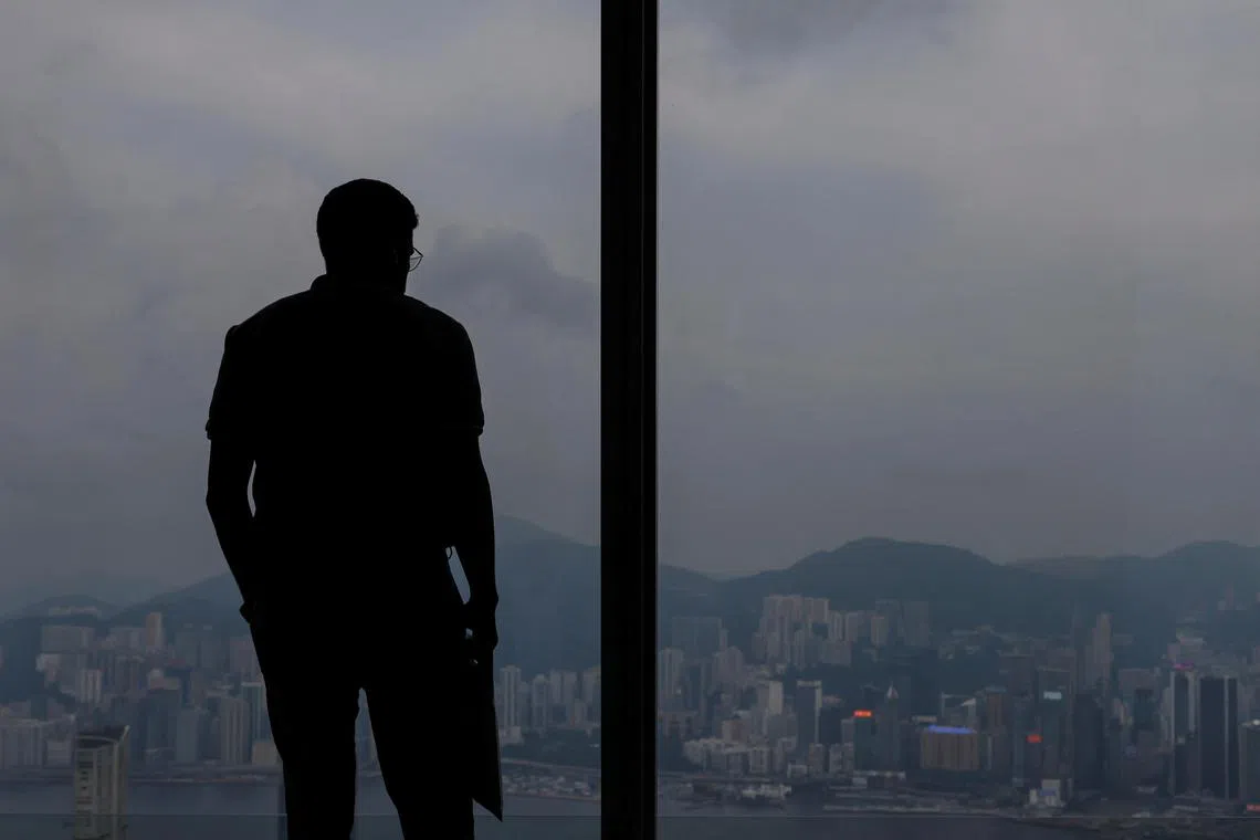 A man looks down at the scenic view of the city from an observation deck in Hong Kong, China June 25, 2023. REUTERS/Tyrone Siu