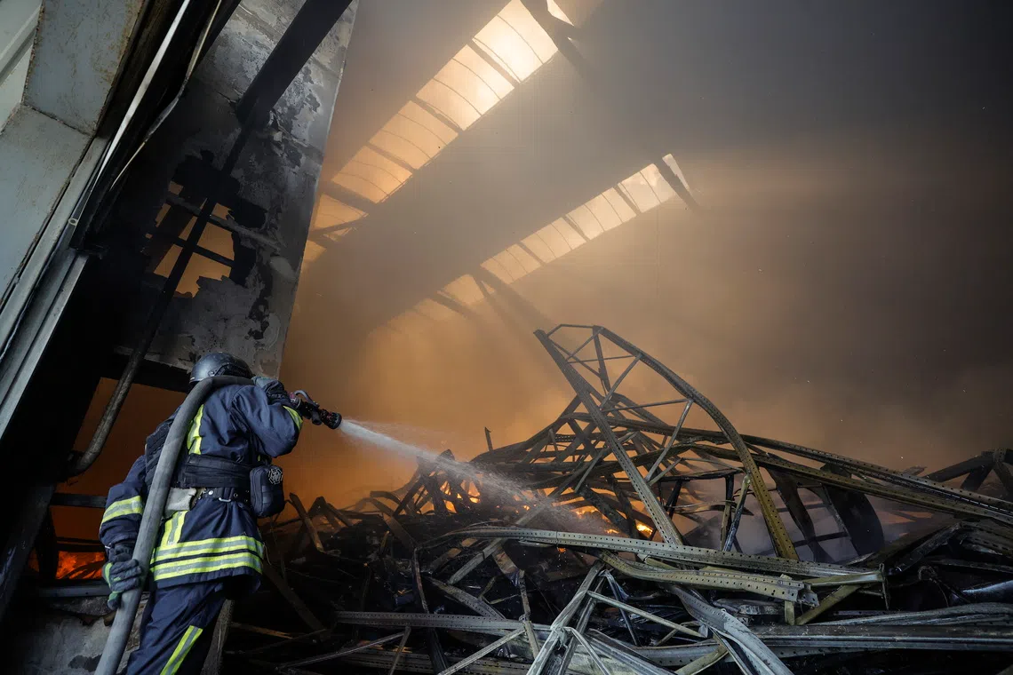 Ukrainian rescuers working at the site of a Russian drone strike on warehouses near Kyiv, on Sept 2.