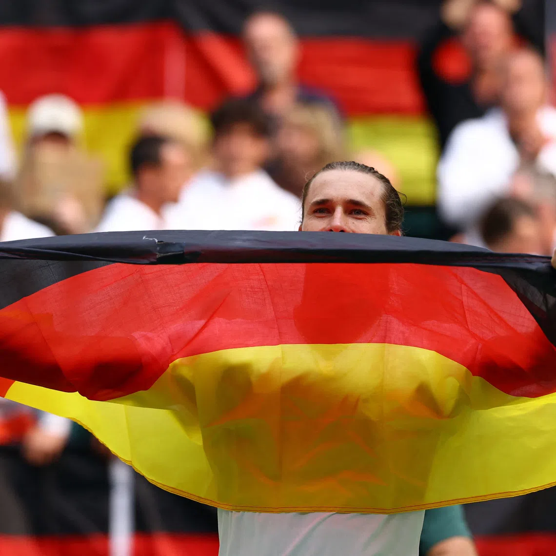 Tennis - Davis Cup - Qualifiers - Second Round - Germany v Croatia - Heristo Arena, Halle, Germany - September 20, 2026 Germany's Alexander Zverev celebrates with his national flag after winning his match against Croatia's Dino Prizmic and qualifying for the Davis Cup REUTERS/Piroschka Van De Wouw