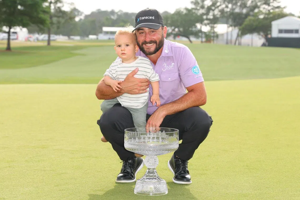 Stephan Jager of Germany posing for a photo with the trophy and his son after winning the PGA Houston Open at Memorial Park Golf Course on March 31.