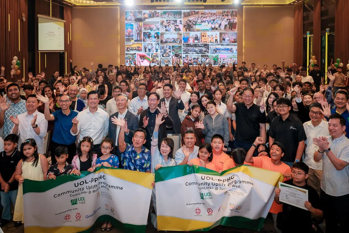 Education Minister Desmond Lee (front row, centre, right) and Senior Parliamentary Secretary for Social and Family Development Eric Chua (front row, centre, left) at the annual UOL-PPHG Community Uplift Programme awards ceremony.