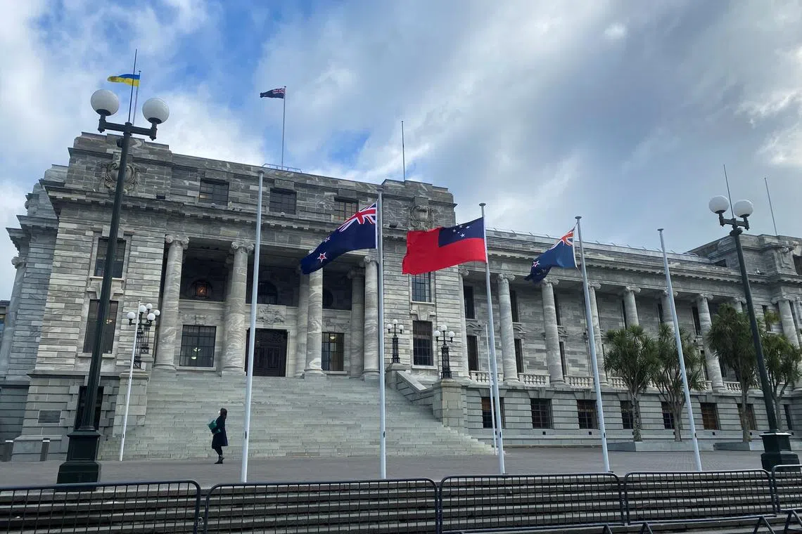 A pedestrian walks past the New Zealand Parliament Buildings in Wellington, New Zealand, June 14, 2022. REUTERS/Lucy Craymer/ File Photo