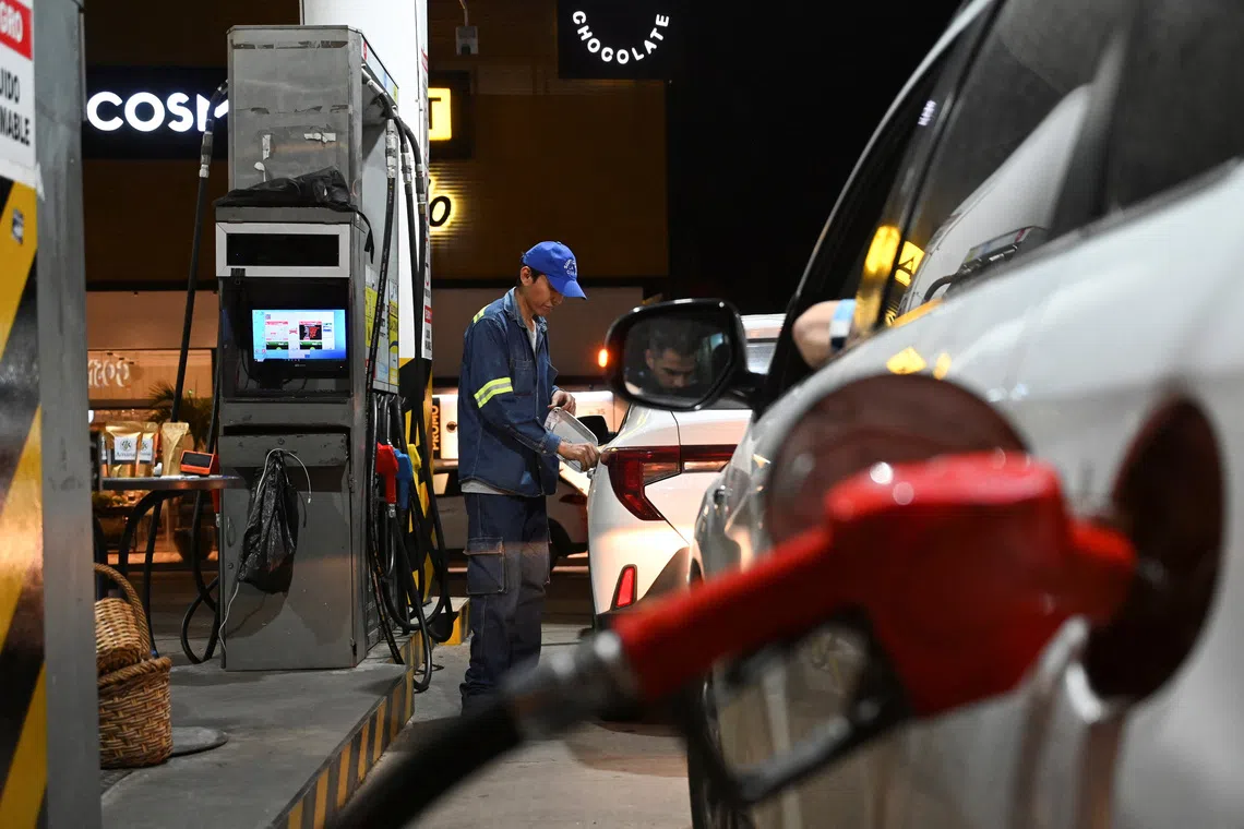 A person refuels a car after Bolivian President Rodrigo Paz announced his government would remove long-standing fuel subsidies in a bid to shore up public accounts, in Santa Cruz, Bolivia, December 17, 2025. REUTERS/Claudia Morales