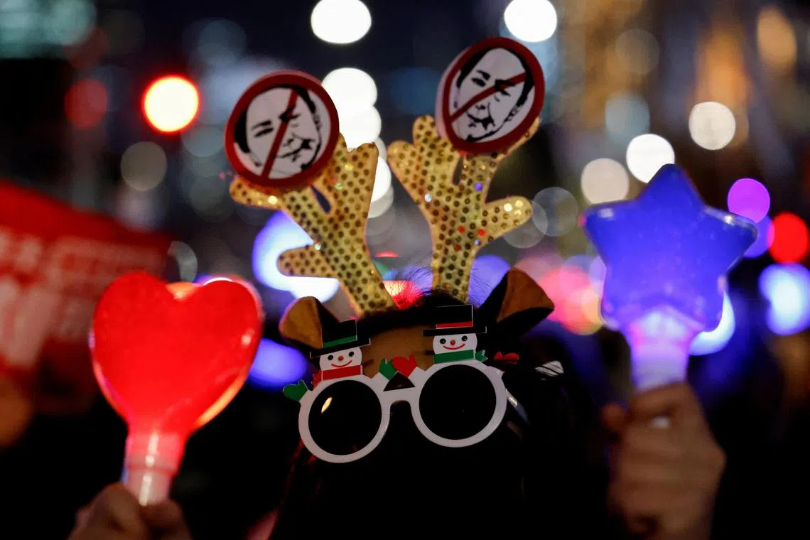 A protester wearing sunglasses takes part in a rally calling for the impeachment of South Korean President Yoon Suk Yeol, who declared martial law, which was reversed hours later, near the National Assembly in Seoul, South Korea, December 13, 2024. REUTERS/Kim Soo-hyeon