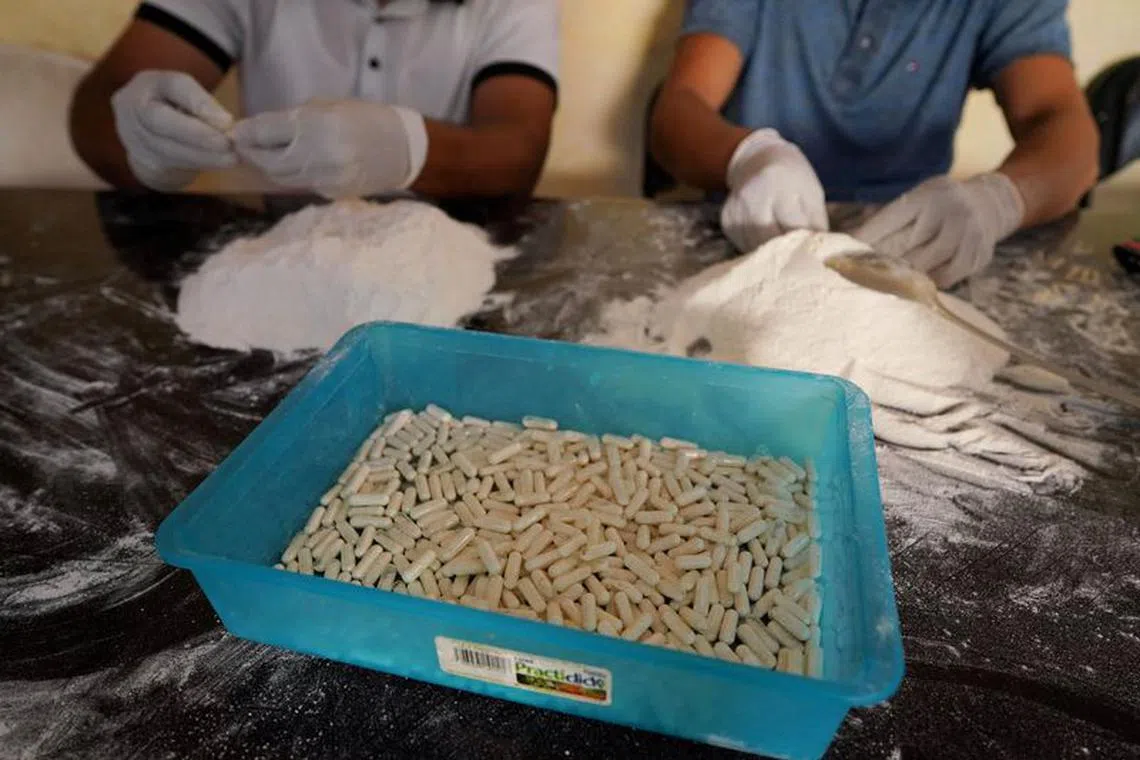 FILE PHOTO: Members of the Sinaloa Cartel prepare capsules with methamphetamine in a safe house in Culiacan, Mexico, April 4, 2022. REUTERS/Alexandre Meneghini/File Photo