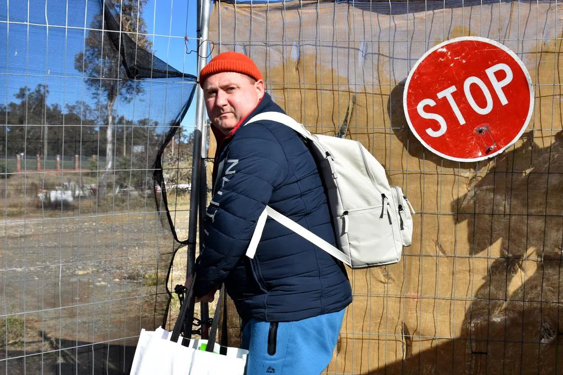 A Russian diplomat leaves a plot of land where Russia intended to build a new embassy near Australia's parliament, on June 26.