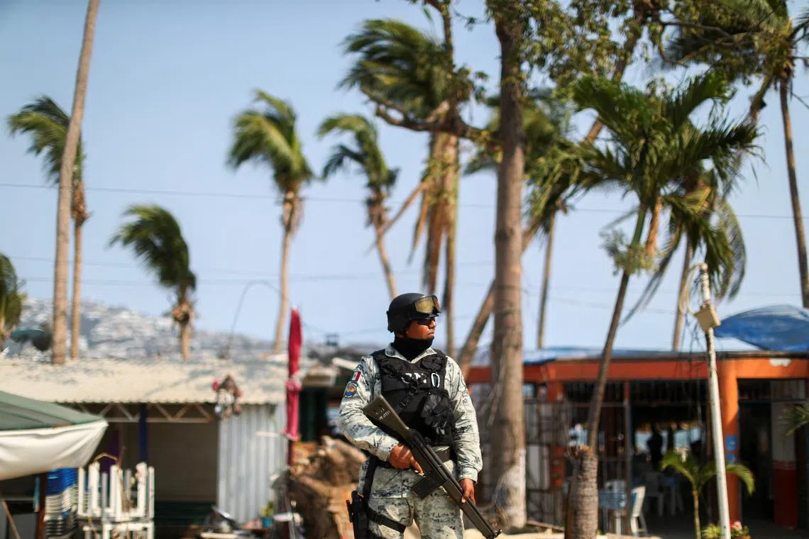 FILE PHOTO: A member of the National Guard stands guard at a crime scene where two people were shot in Acapulco, Mexico, May 7, 2024. REUTERS/Raquel Cunha/File Photo
