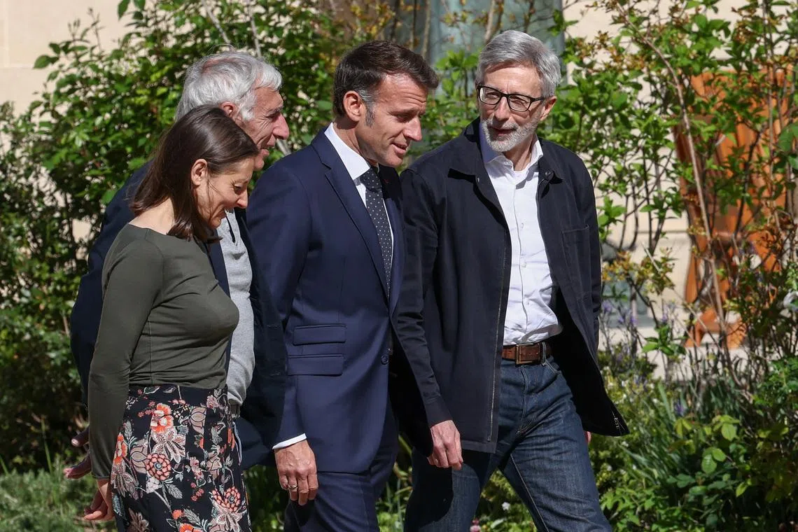 French President Emmanuel Macron walks with Cecile Kohler and Jacques Paris, two French nationals freed by Iran after three and a half years in detention, and French ambassador to Iran Pierre Cochard, at the Elysee Palace in Paris, France, April 8, 2026. REUTERS/Tom Nicholson/Pool