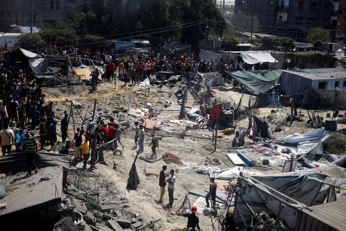 Palestinians inspect the damage, following what Palestinians say was an Israeli strike at a tent camp in Al-Mawasi area, amid Israel-Hamas conflict, in Khan Younis in the southern Gaza Strip July 13, 2024. REUTERS/Mohammed Salem