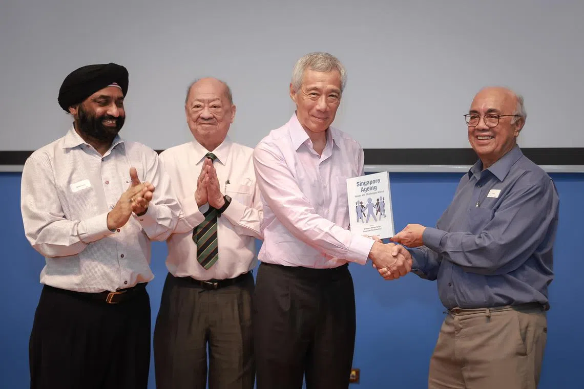 PM Lee Hsien Loong being presented the book “Singapore Ageing: Issues and Challenges Ahead” by NUS Emeritus Professor Dr S Vasoo (right) at the book’s launch held at the Shaw Foundation Alumni House, on April 11. With them are (from left) Department of Political Science Associate Professor Bilveer Singh and Chairman and Editor-in-Chief World Scientific Dr Phua Kok Khoo.