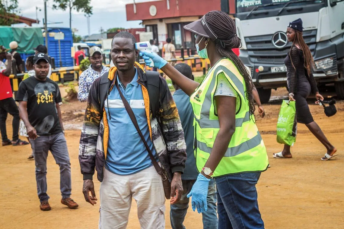 A Kenyan Ministry of Health official checking the temperature of a traveller at the border with Uganda on Oct 12.