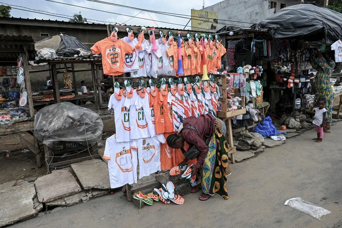 A shopkeeper selling Ivory Coast national team football kits ahead of the 2024 African Cup of Nations at a stall in the Abobo commune of Abidjan. 