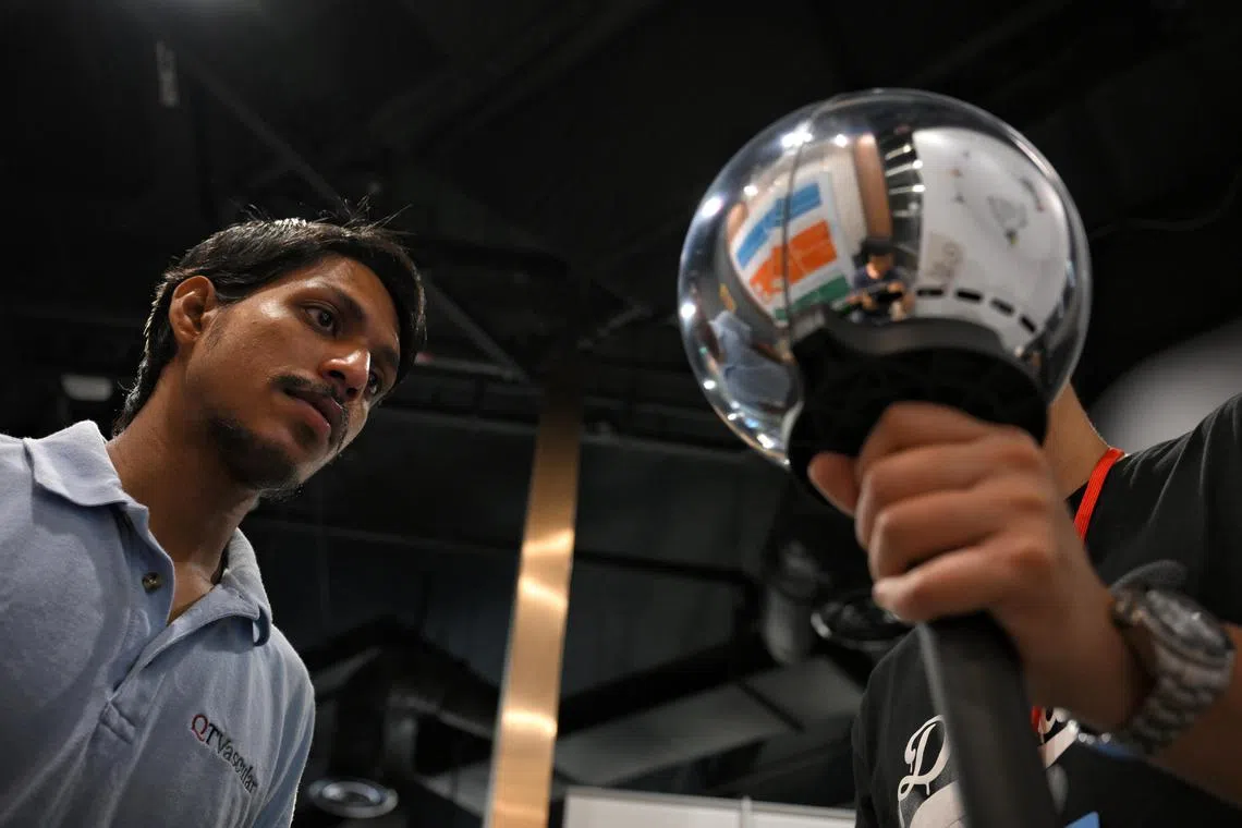 A customer gets his eyes scanned by a Worldcoin Orb at OGBC Innovation Hub on June 10, 2024. Many people, mostly foreigners, are thronging to these silver orbs around Singapore to have their biometrics scanned in exchange for crypto. The initiative by Worldcoin claims to provide unique identity verification using the biometrics.