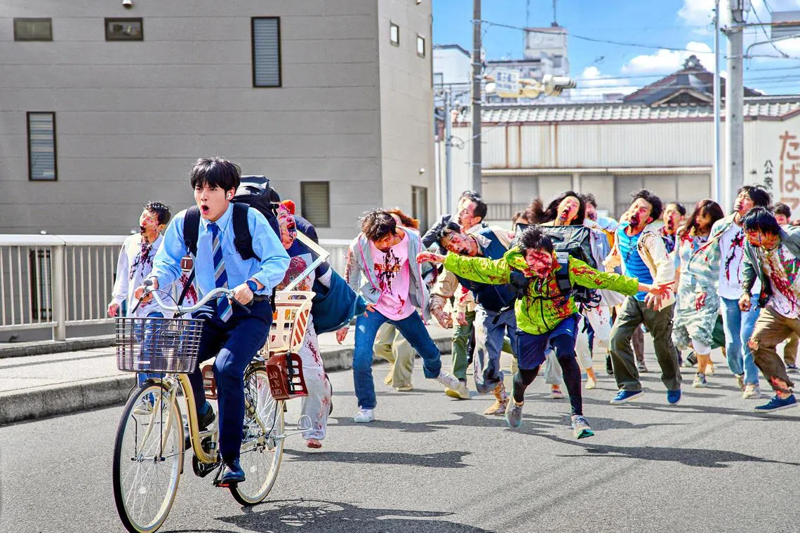 jasneaks02 - Eiji Akaso (in blue on bicycle) plays a salaryman trying to do 100 things on his bucket list amid a zombie apocalypse. 

PHOTO: NETFLIX