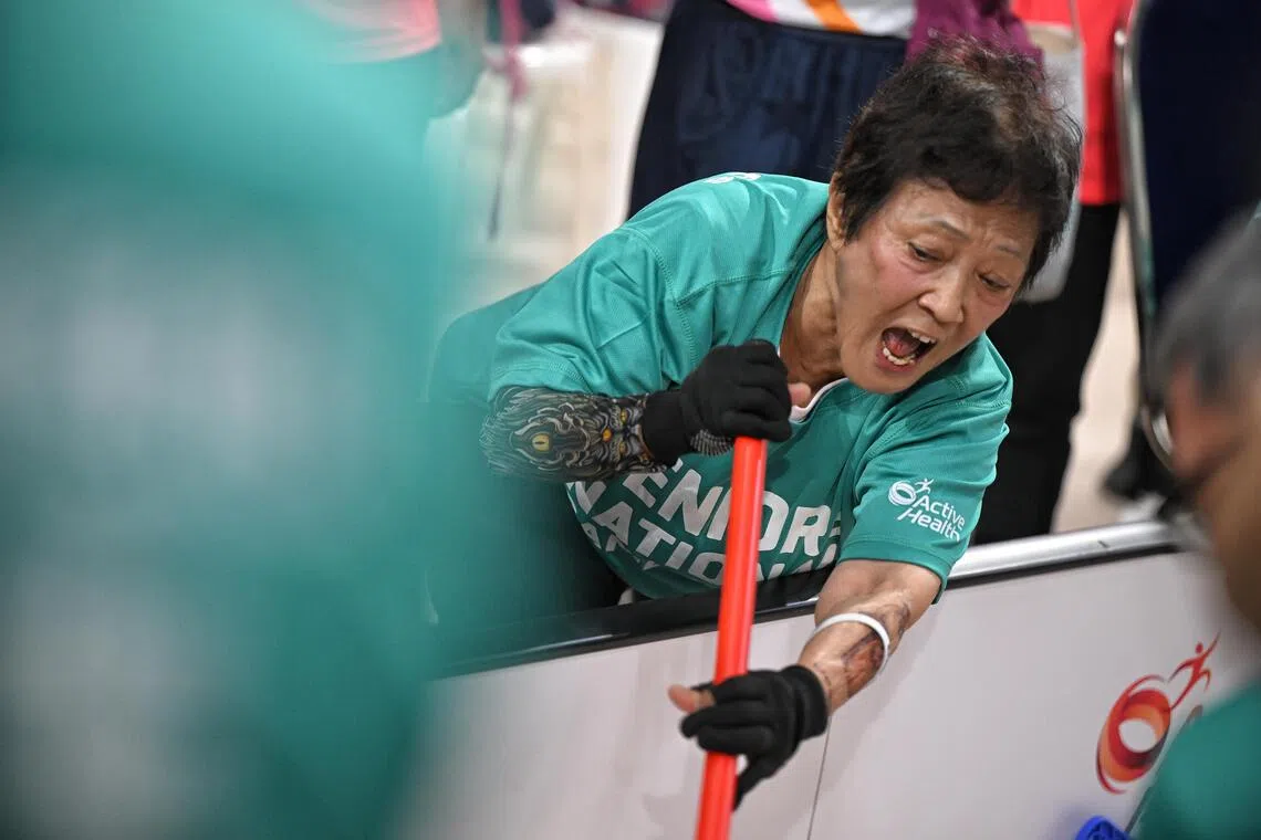 Donning an arm sleeve with tattoo motifs, Madam Kim Cho, 75, dons an arm sleeve with tattoo motifs while competing in seated floorball with her team from the Lions Befrienders (Bendemeer 32) Active Ageing Centre.