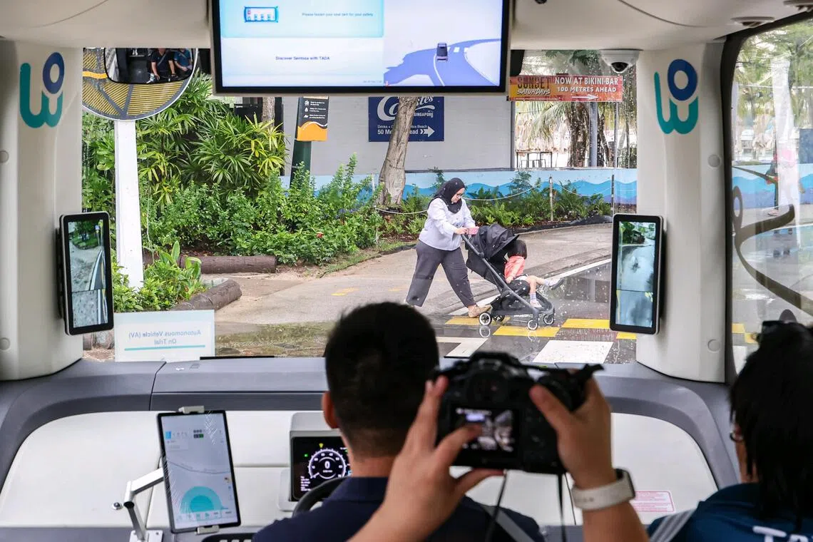 A pedestrian crossing the road along Siloso Beach Walk during the preview of Sentosa’s on-demand autonomous robobus service.