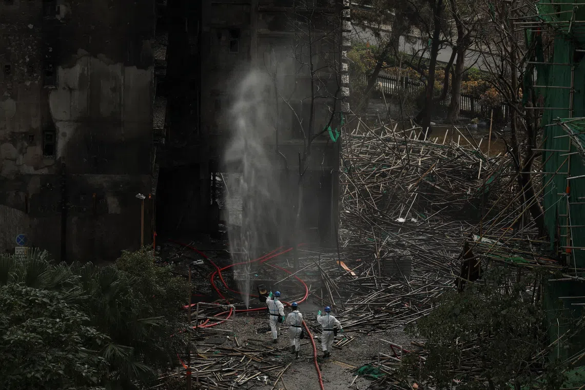Police officers with the Disaster Victim Identification Unit at the scene of the deadly fire at the Wang Fuk Court complex in Tai Po on Dec 1.