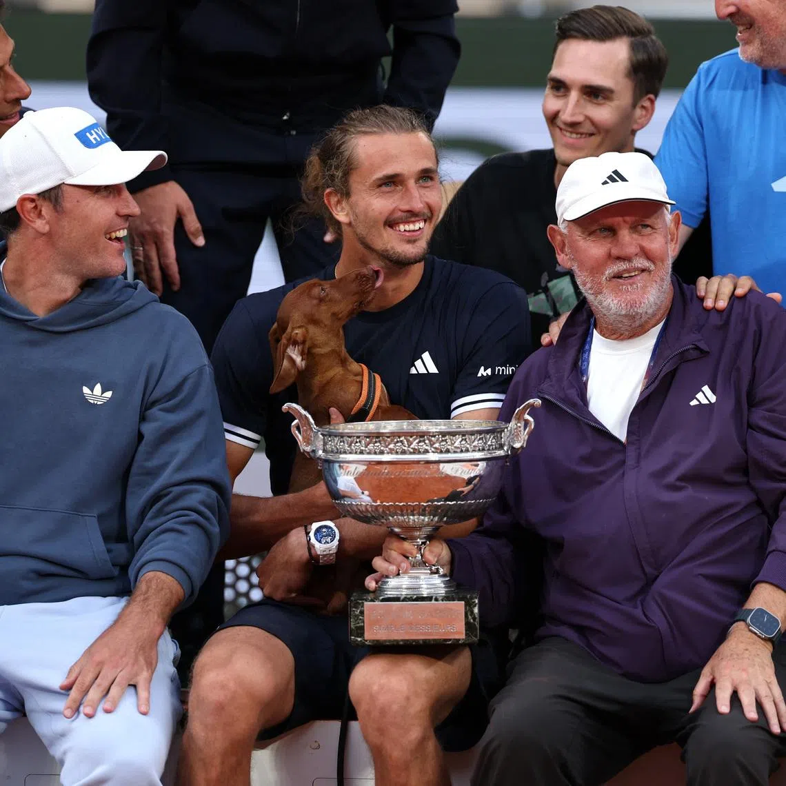 Tennis - French Open - Roland Garros, Paris, France - June 7, 2026 Germany's Alexander Zverev poses for a photograph with the trophy alongside, his brother, Mischa Zverev and dad, Alexander Zverev Sr. as he celebrates winning the final against Italy's Flavio Cobolli REUTERS/Stephane Mahe