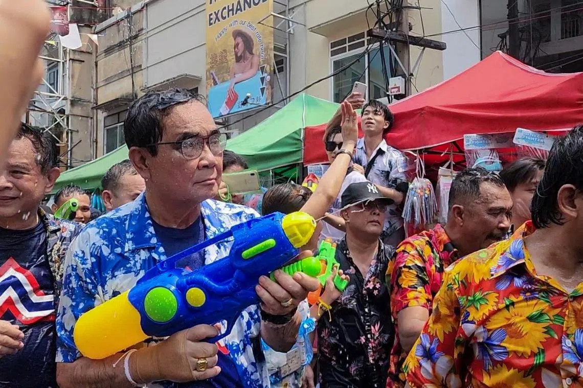 Thailand's Prime Minister Prayuth Chan-ocha, the prime ministerial candidate from the United Thai Nation Party, plays with water as he celebrates the Songkran holiday which marks the Thai New Year in Bangkok on Friday.