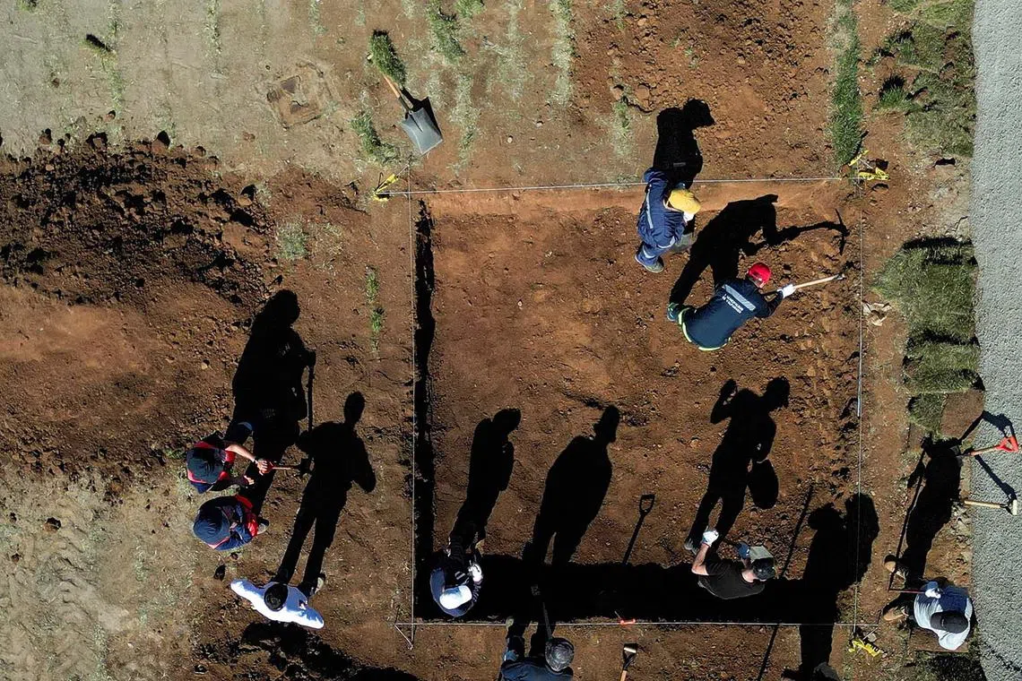 A drone view shows members of a forensic team searching for remains of British priest Michael "Miguel" Woodward and others, who were tortured and disappeared during the 17-year dictatorship of General Augusto Pinochet, at a cemetery, in Valparaiso, Chile April 2, 2025. REUTERS/Rodrigo Garrido TPX IMAGES OF THE DAY