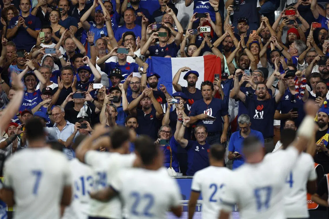 French players celebrating with their fans after winning the Rugby World Cup Pool A match against New Zealand in Saint-Denis.