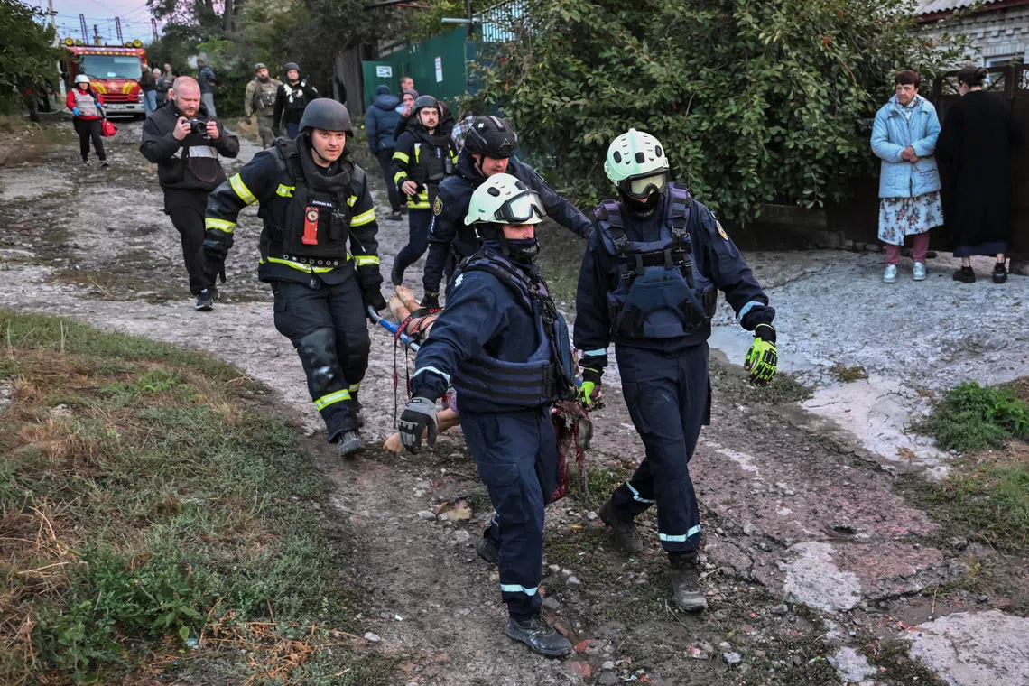 Rescuers carry a wounded person at the site of destroyed private houses hit during a Russian drone strike in Zaporizhzhia, Ukraine.