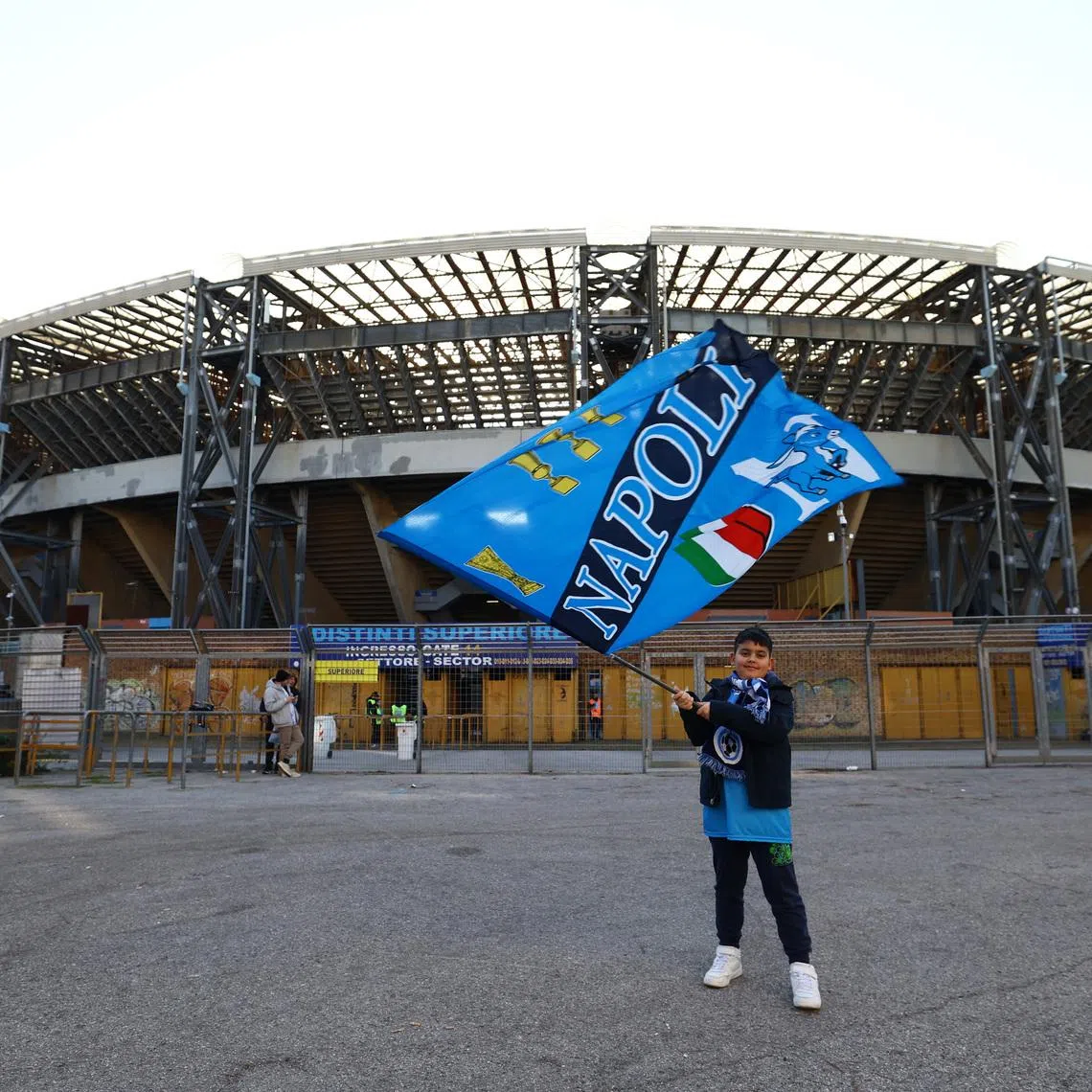 Soccer Football - Serie A - Napoli v U.S. Sassuolo - Stadio Diego Armando Maradona, Naples, Italy - January 17, 2026 A Napoli fan holds a flag outside the stadium before the match REUTERS/Ciro De Luca